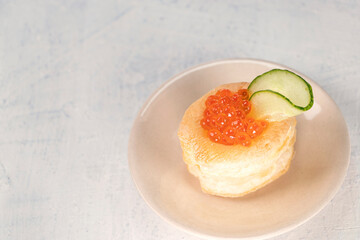 top view of appetizer with red caviar. Tartlets, red caviar, cucumber on a white background with space for your text. Delicious and healthy snack.