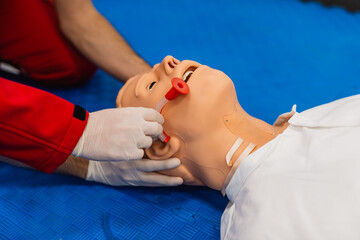 Medical manipulation for airway management. Nasopharyngeal tube airway insertion by stuff in a black gloves on a simulation mannequin dummy during medical training. ACLS