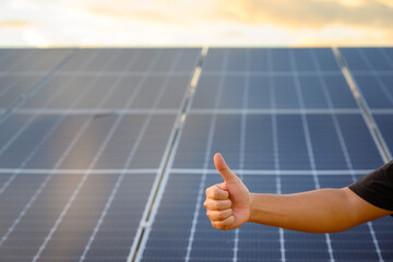 Close-up shot poses positive gesture on solar panel photovoltaic On the roof of the house and with...