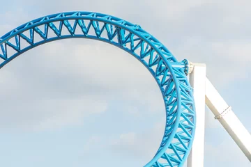 Rolgordijnen Loop and turn on blue color roller coaster in an amusement park. © aapsky
