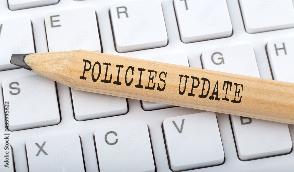 Aufkleber policies update text on pencil on the keyboard background