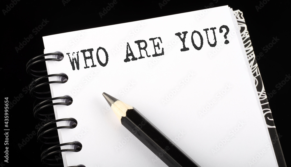 Poster who are you written text in small notebook on a black background