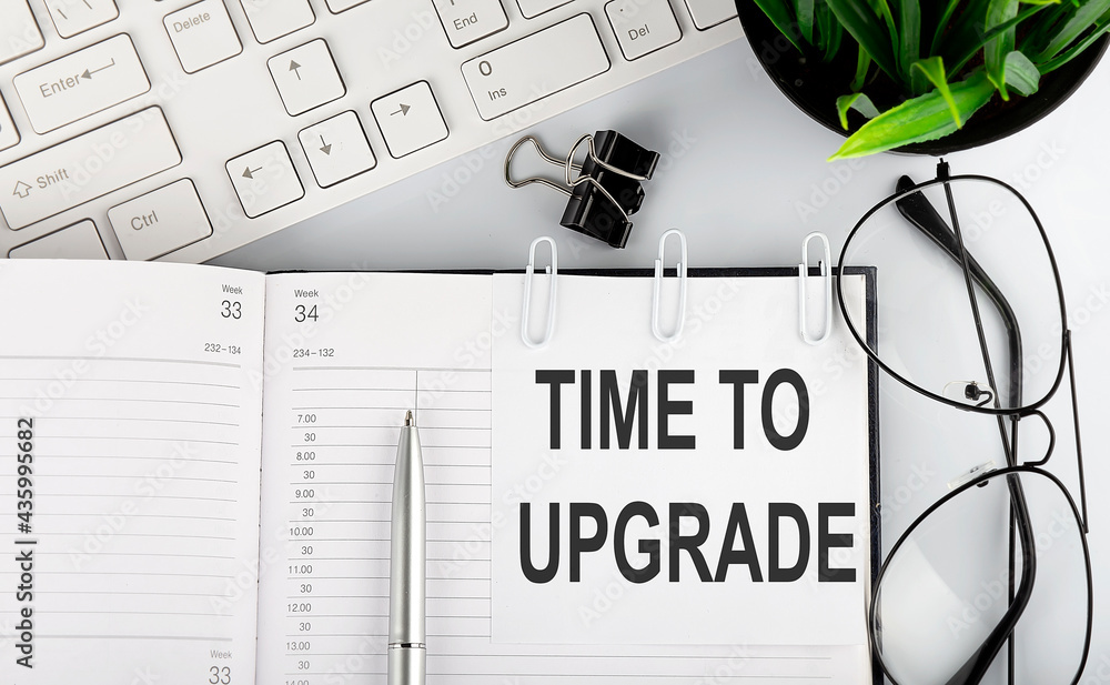 Aufkleber text time to upgrade on calendar planner to remind you an important appointment with a pen and keybo
