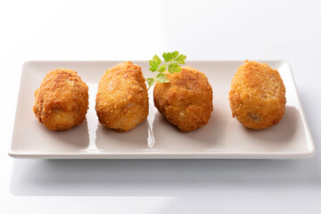 Tapa of croquetas, typical spanish dish, on white background