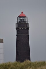 A brick lighthouse against a gray sky