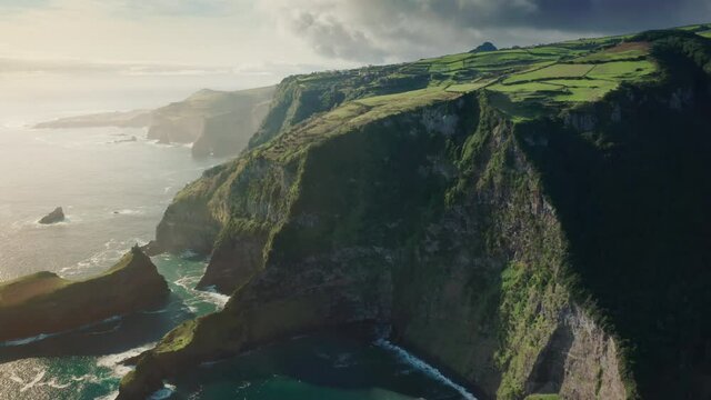 Panoramic view of Casa do Gato Tomas point of green Flores Island, Azores, Portugal, Europe. Drone shot of mountains landscape of island in atlantic ocean. Rocky cliffs covered green fields, footage 