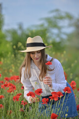 Young girl in the spring poppy field