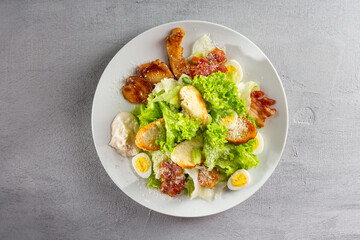 Chicken caesar salad close up on light gray surface
