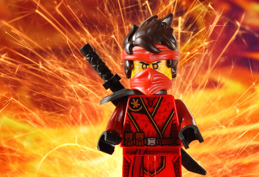 Editorial illustrative image of lego minifugure Kai red ninja with sword weapon on fire background