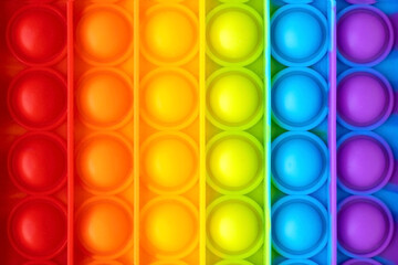 Colorful anti-stress fidget push pop it sensory toy for children close up. Simple dimple. Top view, flat lay.