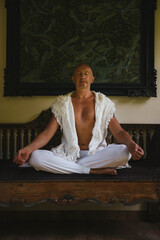 Man sitting on the sofa in lotus position