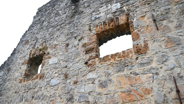 Ruins of an old blast furnace in village Dvor, Slovenia. Only walls remained. Ruins of mighty ironworks. Close up view of stones and bricks. Tilt down