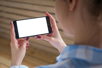 Mock up, copyspace, template and technology concept. Woman looking at black smartphone with white blank screen. Close up view of woman hands with smart phone mobile device - mockup image © zyabich