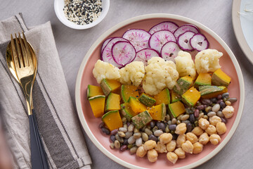 Healthy vegan lunch bowl, buddha bowl salad. chickpeas, radish, pumpkin with cauliflower  and vegetables. Healthy balanced vegetarian food concept.