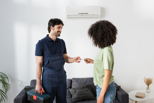 Happy Handyman Giving Blank Card To Curly African American Woman