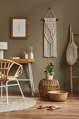 Stylish bohemian interior of home office space with wooden desk, rattan armchair, brown mock up...
