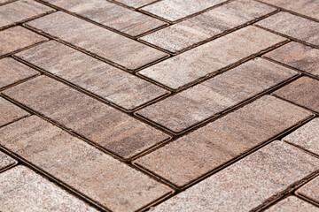Elongated brown paving stones with streaks are laid under the parquet floor.  Selective focusing.