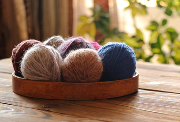 Fototapeta na wymiar Multicolored yarn balls in wood basket for knitting and crocheting