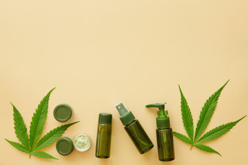 Cosmetics with cannabis oil on a yellow background. Copy space, Flat lay composition with hemp lotion. mockup. Jar of hemp green  lotion. Cannabis cream with marijuana leaf