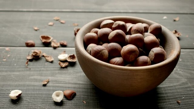 Nuts in a wooden bowl on a table. Dolly shot