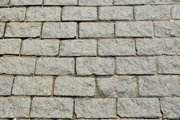 Paving stones from rectangular granite stones. Background, texture. design. A fragment of the sidewalk.