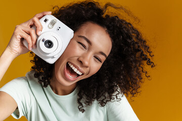 Young african woman laughing while posing with camera