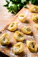 Uncooked pelmeni dumplings on rustic wooden table. typical russian food	