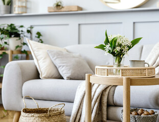 Scandinavian living room interior with design grey sofa, wooden coffee table, plants, shelf, spring...