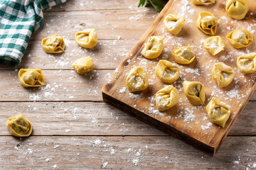 Uncooked pelmeni dumplings on rustic wooden table. Copy space. Typical russian food	