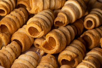 Lots of sweet home made confectionery tubes prepared to be filled with cream. Photo taken under soft artificial light.