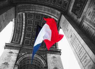 French flag waving under Arc de Triomphe in honor of VE day. Paris, France