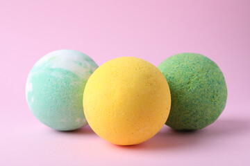 Colorful bath bombs on pink background, closeup