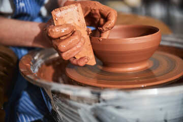 Competent craftsperson using tools for molding bowl