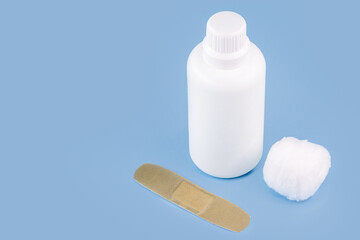 hydrogen peroxide, in white plastic packaging, with band aid and isolated blue background, antiseptic medicine