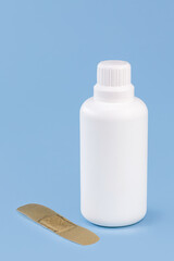 hydrogen peroxide, in white plastic packaging, with band aid and isolated blue background, antiseptic medicine