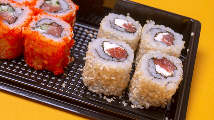 small portion of rolls with fish on an orange background