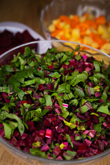 Fresh, chopped beetroot leaves arranged in a glass bowl. Photo taken under artificial, soft light.