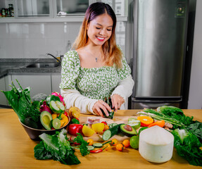 Asian girl cooking healthy vegetarian and vegan food, vegetables and fruits in the kitchen, healthy lifestyle