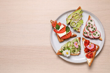 Different tasty sandwiches served on wooden table, top view. Space for text