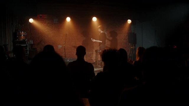 DOLLY Young Caucasian male comedian entering stage and greeting audience, performing his stand-up monologue inside a small venue. Shot with ARRI Alexa Mini LF with 2x anamorphic lens
