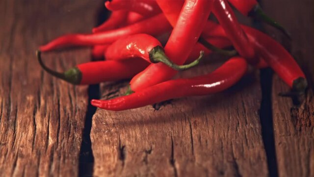 Super slow motion red chilli rolls on wooden boards. Filmed on a high-speed camera at 1000 fps.High quality FullHD footage