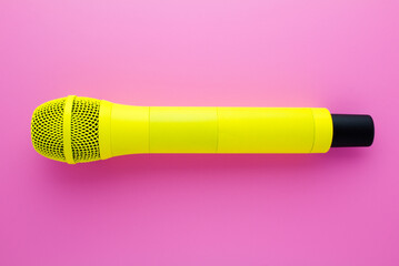 Yellow professional vocal wireless microphone on pink background.