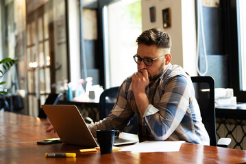 Businessman sitting looking at his laptop. Businessman working in the office on his laptop.