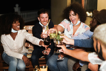 Happy multiracial people having fun drinking cocktails at terrace party during coronavirus outbreak - Main focus on center girl face