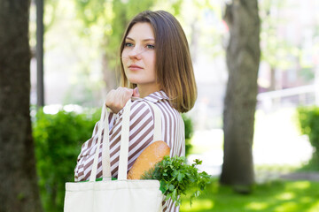 Woman holding sustainable eco bag with groceries. Ecological shopping and zero waste life style concept