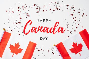 Happy Canada Day banner mockup. Canadian flags and confetti on white table. Flat lay, top view,...