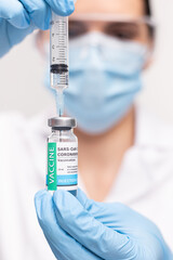 SARS - CoV2 Vaccination concept. Close up COVID-19 vaccine dose. A doctor or nurse in a laboratory holds a vial with a vaccine. Pandemic immunity.