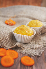 orange carrot cupcake on wooden table on sackcloth, selective focus