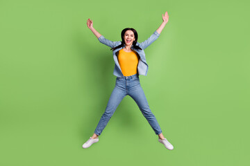 Fototapeta na wymiar Full size photo of funny nice brown hairdo lady jump wear jeans shirt isolated on pastel green color background
