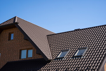 Brown corrugated metal profile roof installed on a modern house. The roof of corrugated sheet. Roofing of metal profile wavy shape. Modern roof made of metal. Metal roofing.